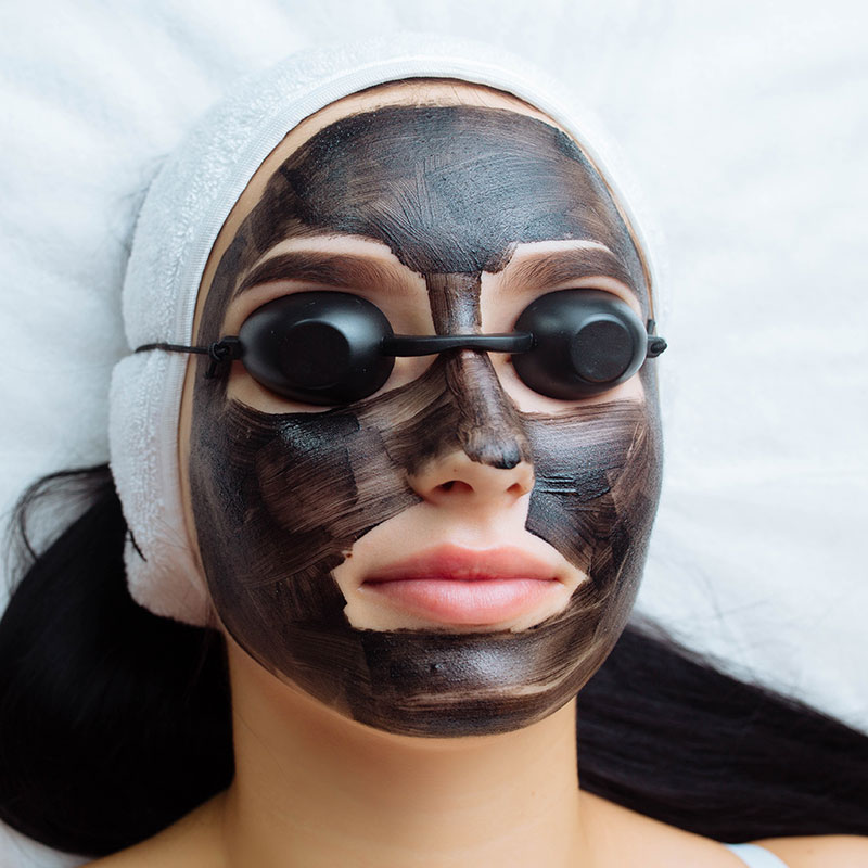cosmetologa-aplicando-mascara-negra-cara-mujer-bonita-guantes-negros-hermosa-mujer-spa-h